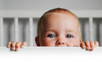 Baby peaking up from crib.